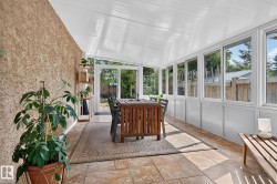 Sunroom featuring tiled flooring, a textured wall, multiple windows, and a white paneled ceiling - 