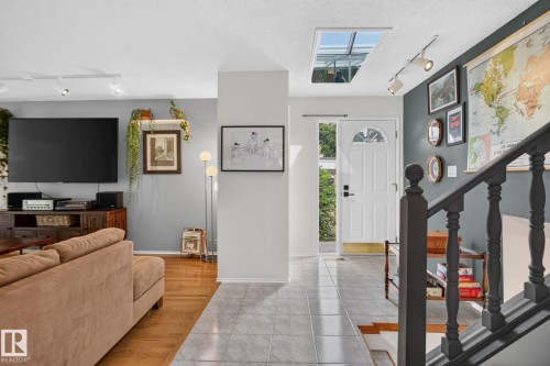 Skylight entry, wood-finish flooring, tile flooring, track lighting, and a paneled entry door - 12 Latimer Place, St. Albert, AB - Indoor Photo Showing Other Room