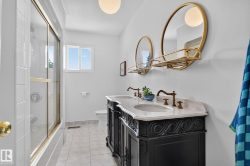 Dual vanity with ornate black cabinetry, white countertop, and brass-finish fixtures - 12 Latimer Place, St. Albert, AB - Indoor Photo Showing Bathroom