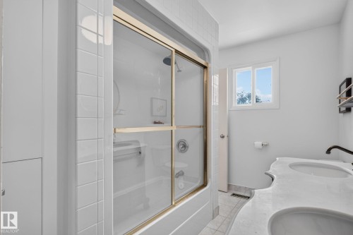 Shower-over-tub with sliding glass enclosure and gold-tone frame - 12 Latimer Place, St. Albert, AB - Indoor Photo Showing Bathroom