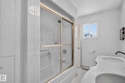 Shower-over-tub with sliding glass enclosure and gold-tone frame - 