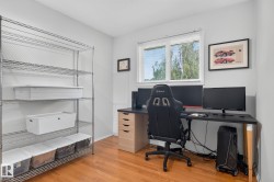Hardwood-style flooring, white walls, and a large window with blinds - 