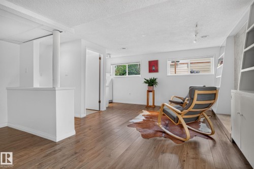 Spacious room featuring wood-finish flooring, white walls, and built-in shelving - 12 Latimer Place, St. Albert, AB - Indoor