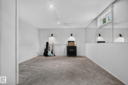 Recessed window with exterior light, mirrored wall panels, accent wall with sconce lighting, track lighting, and wall-to-wall carpeting - 
