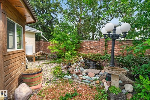 Exterior landscaping featuring a water feature, stone accents, and a brick privacy wall - 12 Latimer Place, St. Albert, AB - Outdoor