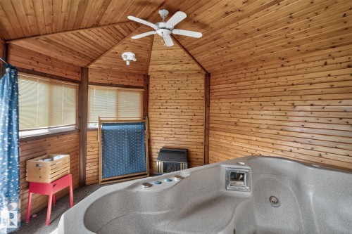 Indoor hot tub with wood-paneled walls and ceiling, accompanied by a ceiling fan - 12 Latimer Place, St. Albert, AB -  With Fireplace