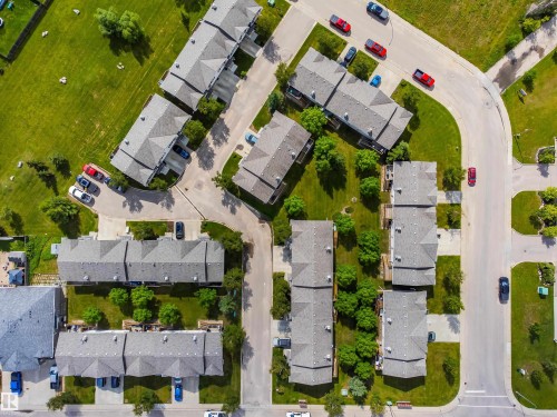 Residential community featuring multiple buildings with gabled roofs, paved driveways, and surrounding green spaces - #9 6506 47 St, Cold Lake, AB - Outdoor With View