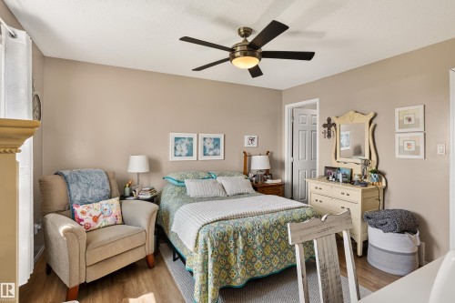 Ceiling fan light fixture, wood-finish flooring, and neutral wall tones - #9 6506 47 St, Cold Lake, AB - Indoor Photo Showing Bedroom
