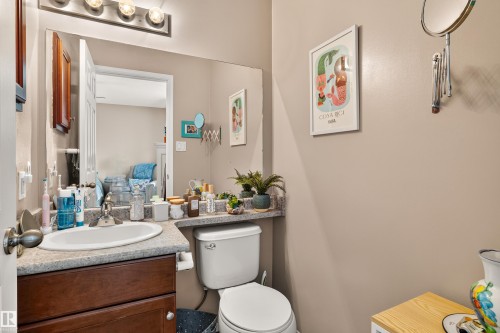 Bathroom vanity with an undermount sink, wood-finish cabinetry, and a light-toned countertop - #9 6506 47 St, Cold Lake, AB - Indoor Photo Showing Bathroom