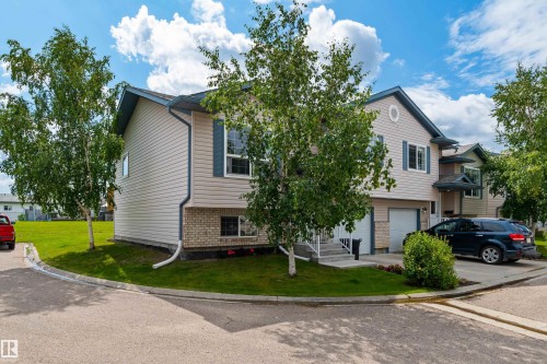 Two-story exterior with light-toned siding and brick accents - #9 6506 47 St, Cold Lake, AB - Outdoor With Facade