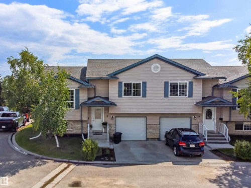 Two-story townhome with light-colored siding and dark blue trim - #9 6506 47 St, Cold Lake, AB - Outdoor With Facade