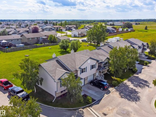 Multi-level residential property featuring a light-colored stucco exterior, attached garages, and a paved driveway - #9 6506 47 St, Cold Lake, AB - Outdoor With View