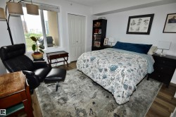 Wide plank wood-finish flooring, white painted walls, and a large window with a white frame - 