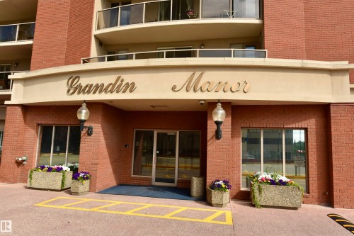 Elegant brick facade with a welcoming entrance featuring a curved awning, recessed lighting, and glazed glass doors - #706 9741 110 St Nw, Edmonton, AB - Outdoor With Balcony With Exterior