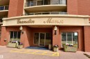 Elegant brick facade with a welcoming entrance featuring a curved awning, recessed lighting, and glazed glass doors - #706 9741 110 St Nw, Edmonton, AB  - Outdoor With Balcony With Exterior 