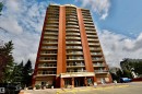 Brick facade high-rise with multiple floors of private balconies featuring glass railings - #706 9741 110 St Nw, Edmonton, AB  - Outdoor With Balcony With Facade 