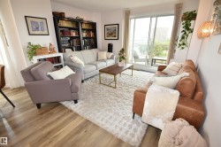 Spacious living area featuring wood-finish flooring, a full-height built-in bookshelf, and a sliding glass door leading to a private outdoor space - 