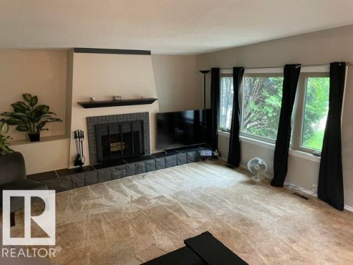Fireplace featuring a black brick surround and hearth, mantel, and built-in shelving - 27 Gatewood Avenue, St. Albert, AB - Indoor Photo Showing Living Room With Fireplace