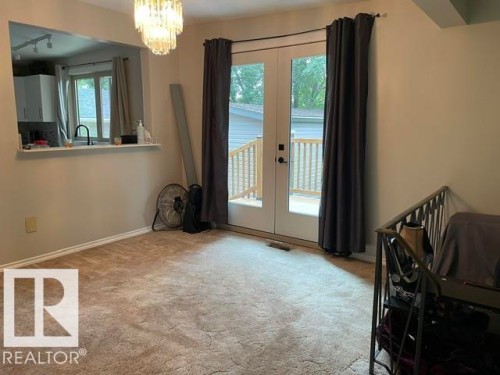 Glass-paneled double doors open to an outdoor deck - 27 Gatewood Avenue, St. Albert, AB - Indoor Photo Showing Other Room