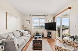 Light wood-finish flooring, white painted walls, window with blinds, and white-framed sliding glass door - 