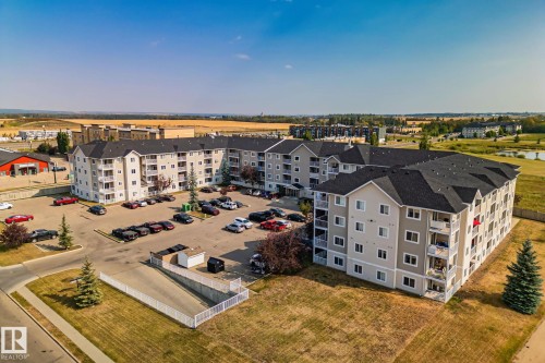 Multi-story apartment building with dark shingle roof and light-colored siding - #407 4309 33 St, Stony Plain, AB - Outdoor With View