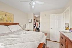 White ceiling fan with integrated lighting, wood-finish flooring, and white paneled door - 