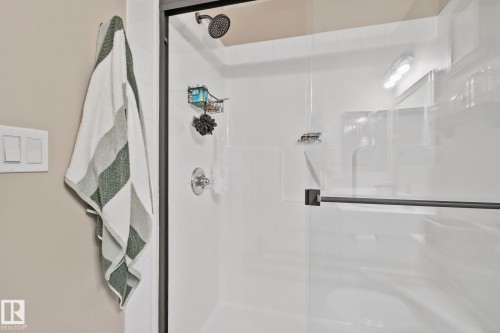 Glass-enclosed shower with a matte black frame, rain showerhead, and polished chrome fixtures - #407 4309 33 St, Stony Plain, AB - Indoor Photo Showing Bathroom