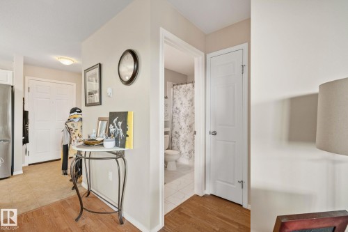 Wood-finish flooring, white paneled doors, and a tiled bathroom floor - #407 4309 33 St, Stony Plain, AB - Indoor Photo Showing Laundry Room