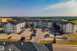Multi-story residential building with private balconies and surface parking - 