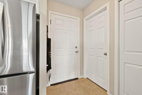 Entryway featuring panel doors, neutral wall tones, and tiled flooring - #407 4309 33 St, Stony Plain, AB - Indoor Photo Showing Other Room