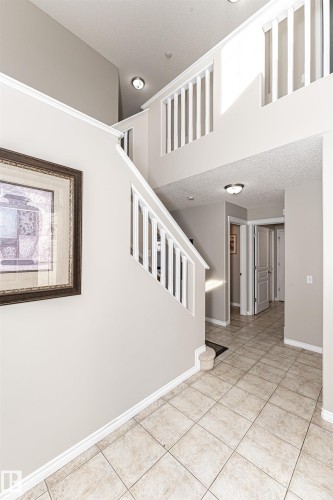 Multi-level entry with ceramic tile flooring, a white spindle staircase, and a vaulted ceiling - 192 Keyport Circle, Leduc, AB - Indoor Photo Showing Other Room