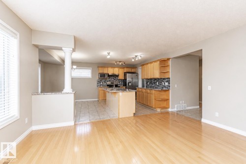 Hardwood flooring, kitchen island with sink, stainless steel appliances, wood cabinetry, and tile backsplash - 192 Keyport Circle, Leduc, AB - Indoor Photo Showing Kitchen
