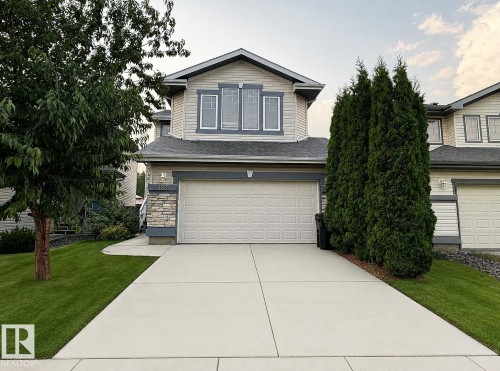 Exterior featuring horizontal siding, stone accents, a gabled roofline, a concrete driveway, and a paneled garage door - 192 Keyport Circle, Leduc, AB - Outdoor