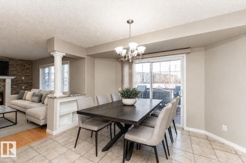 Dining area featuring tile flooring, a chandelier, and a sliding glass door - 192 Keyport Circle, Leduc, AB - Indoor Photo Showing Dining Room With Fireplace