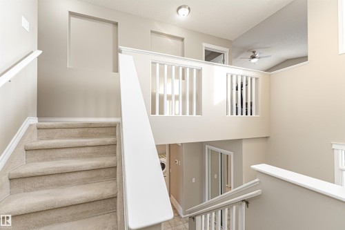 Carpeted staircase with white railings, leading to an upper landing - 192 Keyport Circle, Leduc, AB - Indoor Photo Showing Other Room