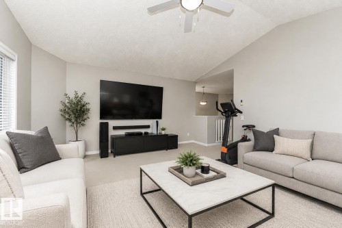 Staged with AI - Vaulted ceiling, ceiling fan, neutral wall paint, carpet flooring, window with blinds - 192 Keyport Circle, Leduc, AB - Indoor Photo Showing Living Room