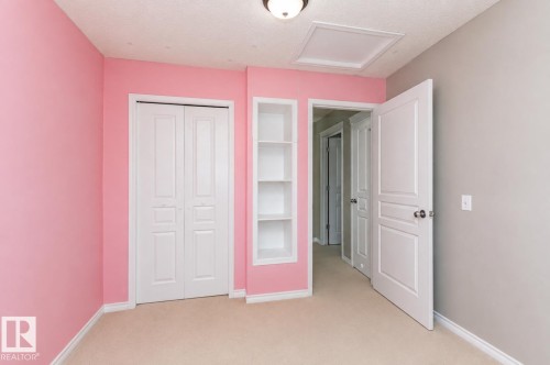 Built-in shelving unit, neutral carpet flooring, recessed panel doors, and overhead lighting - 192 Keyport Circle, Leduc, AB - Indoor