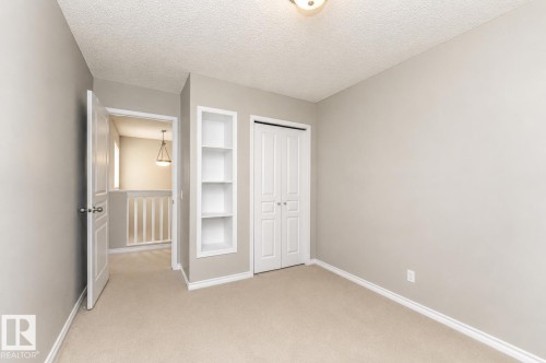 Recessed built-in shelving, carpet flooring, and bi-fold closet doors - 192 Keyport Circle, Leduc, AB - Indoor Photo Showing Other Room