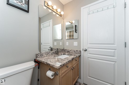 Bathroom vanity featuring a speckled countertop, undermount sink, and light wood-finish cabinetry - 192 Keyport Circle, Leduc, AB - Indoor Photo Showing Bathroom