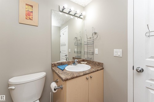 Bathroom vanity featuring a rectangular integrated sink, countertop, and wood-finish cabinetry - 192 Keyport Circle, Leduc, AB - Indoor Photo Showing Bathroom