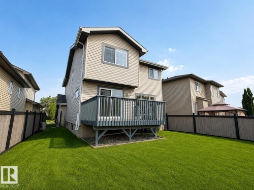 Expansive backyard featuring a manicured lawn, a raised deck, and a privacy fence - 192 Keyport Circle, Leduc, AB - Outdoor With Deck Patio Veranda With Exterior