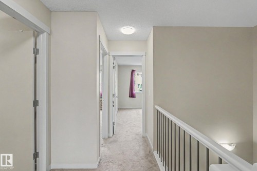 Carpeted hallway with neutral wall tones and white trim - 17304 73 Street Nw, Edmonton, AB - Indoor Photo Showing Other Room
