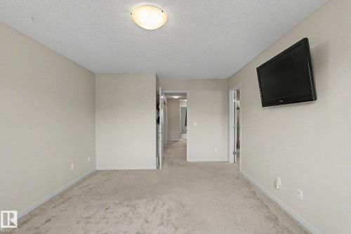 Carpeted room with neutral painted walls and a flush-mount ceiling light fixture - 17304 73 Street Nw, Edmonton, AB - Indoor Photo Showing Other Room