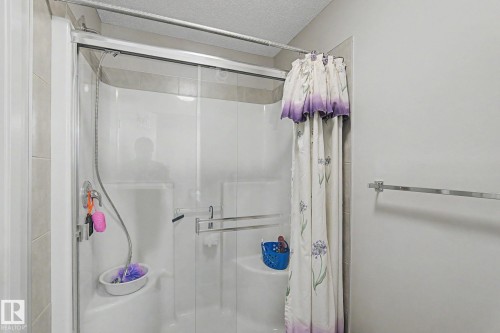 Shower enclosure featuring glass sliding doors, integrated seating, and a chrome shower fixture - 17304 73 Street Nw, Edmonton, AB - Indoor Photo Showing Bathroom