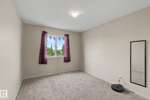 Bedroom featuring neutral-toned walls, gray carpeting, and a window with white trim - 17304 73 Street Nw, Edmonton, AB - Indoor Photo Showing Other Room