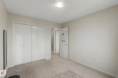 Neutral-toned room featuring a flush-mount ceiling light, light-colored walls, and gray carpeting - 17304 73 Street Nw, Edmonton, AB - Indoor