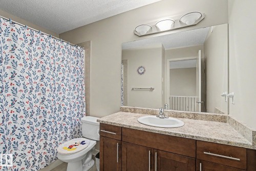 Bathroom featuring a single vanity with a laminate countertop, undermount sink, and dark wood-finish cabinetry - 17304 73 Street Nw, Edmonton, AB - Indoor Photo Showing Bathroom