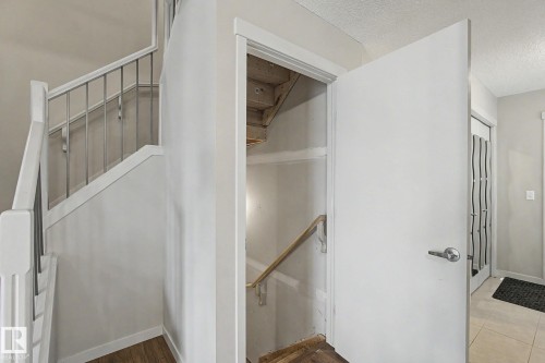 Staircase with white balustrades and silver-toned spindles, complemented by light wood-finish flooring - 17304 73 Street Nw, Edmonton, AB - Indoor