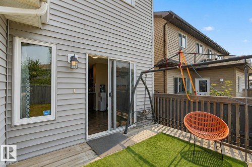 Upper-level deck featuring a wood railing, artificial turf, and a sliding glass door entry to the interior - 17304 73 Street Nw, Edmonton, AB - Outdoor With Deck Patio Veranda With Exterior