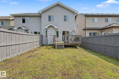 Private backyard featuring a wooden privacy fence, a raised wooden deck with steps, and a vinyl-sided exterior - 17304 73 Street Nw, Edmonton, AB - Outdoor